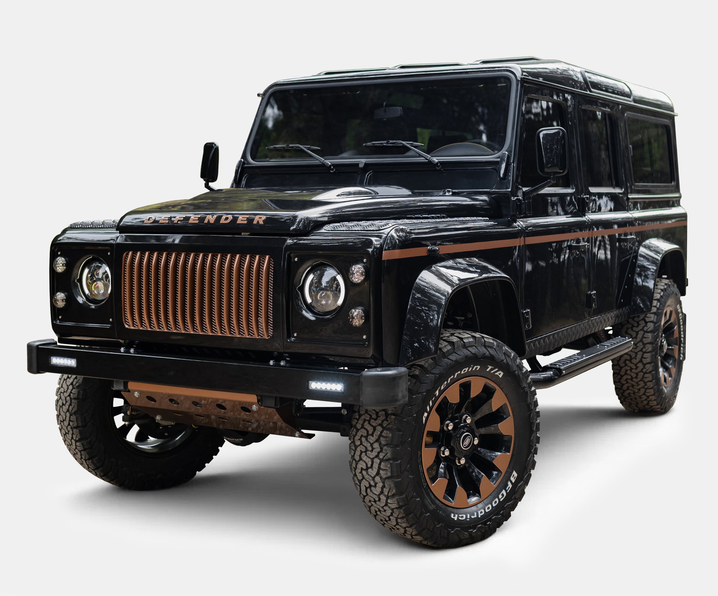 Black custom Land Rover Defender with unique copper grille and off-road tires