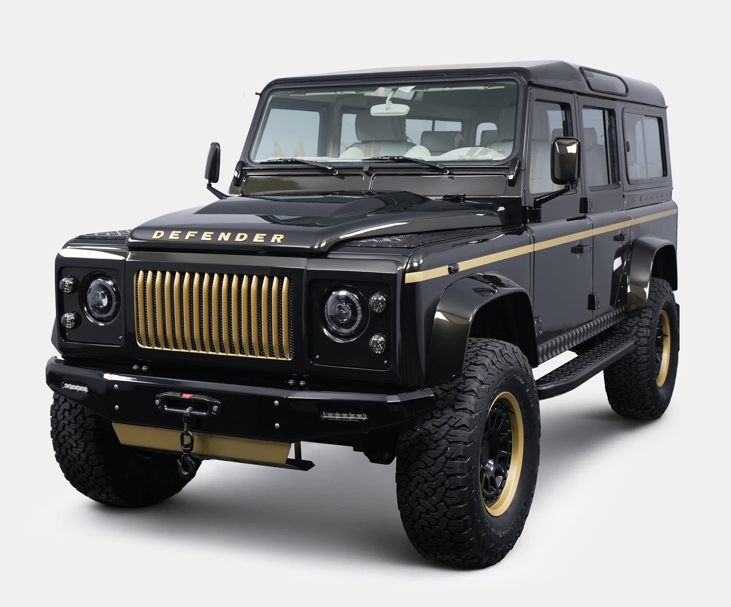 Custom black Land Rover Defender with gold accents and bold grille