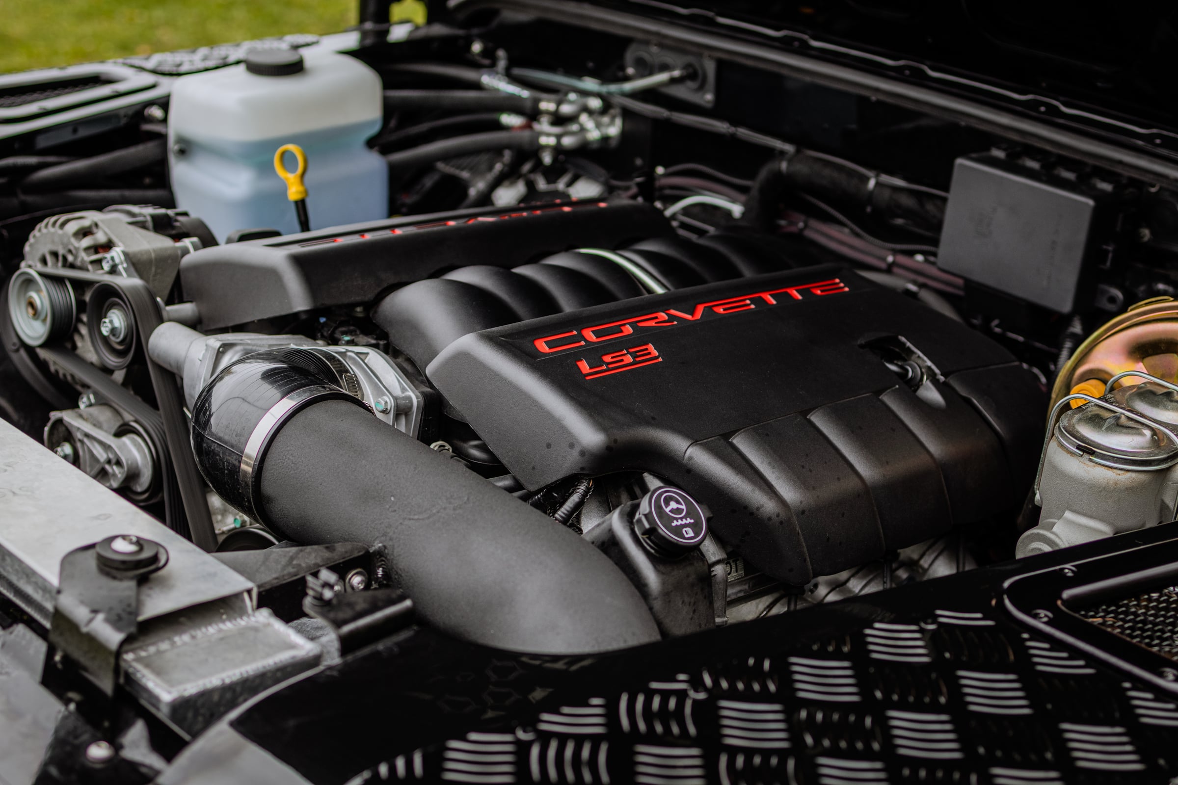 Close-up of LS3 engine with Corvette branding and custom modifications